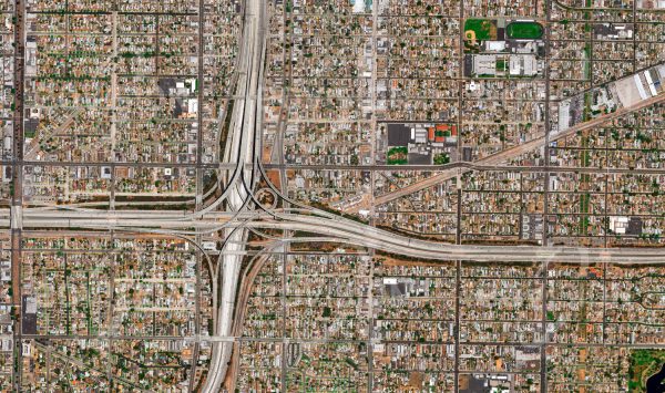 Das Satellitenbild "LOS ANGELES - USA" ist dem Bildband "HUMAN FOOTPRINT - Satellitenbilder dokumentieren menschliches Handeln" entnommen. Bildbeschreibung: Infolge der Nähe von Los Angeles zur San-Andreas-Spalte treten hier immer wieder schwere Erdbeben auf, wie zuletzt 1994. Daher ist die Anzahl von Wolkenkratzern sehr gering, mit der Folge eines großen Flä­chenbedarfs für Wohnbau und auch für die Verkehrsinfrastruktur. Trotz breiter Straßen mit bis zu 15 Spuren, die in Kreuzungen in mehreren Stockwerken übereinander geführt werden, sind Staus in Los Angeles an der Ta­gesordnung.
