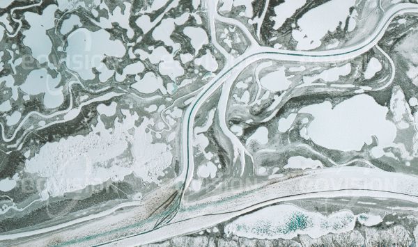 Das Satellitenbild "INUVIK - Kanada" ist dem Bildband "HUMAN FOOTPRINT - Satellitenbilder dokumentieren menschliches Handeln" entnommen. Bildbeschreibung: Im Winter werden die eisbedeckten arktischen Flüsse als Autobahnen genutzt, deren Fahrbahnen im Frühling durch dunkles, blankes Eis erkennbar sind.