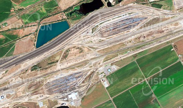 Das Satellitenbild "NORTH PLATTE - USA" ist dem Bildband "HUMAN FOOTPRINT - Satellitenbilder dokumentieren menschliches Handeln" entnommen. Bildbeschreibung: Tausende Güterwaggons, die jeden Tag den weltgrößten Rangierbahnhof Bailey Yard erreichen, werden hier zu neuen Zügen zusammengestellt.