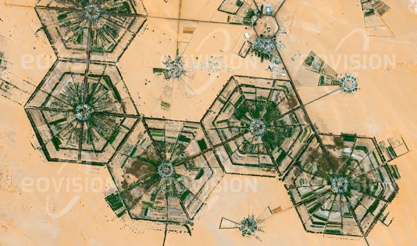 Das Satellitenbild "AL KUFRAH - Libyen" ist dem Bildband "HUMAN FOOTPRINT - Satellitenbilder dokumentieren menschliches Handeln" entnommen. Bildbeschreibung: Das fossile Grundwasser, mit dem die Felder um Al Kufrah bewässert werden, wird wegen des trockenen Klimas kaum nachgebildet, sodass ein Ende der Wasservorräte absehbar ist. Nahe den Mittelpunkten der abgebildeten sechseckigen Strukturen liegen Wohn- und Wirtschaftsgebäude, deren Anbauflächen für Obst und Gemüse innerhalb der Sektoren nach außen angeordnet sind. Die bewirtschafteten Flächen werden an der Außengrenze durch Busch- und Baumreihen vor dem Wüsten-sand geschützt.