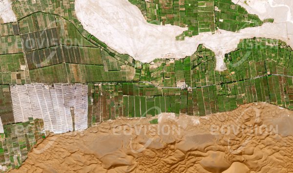 Das Satellitenbild "DADONGHU - China" ist dem Bildband "HUMAN FOOTPRINT - Satellitenbilder dokumentieren menschliches Handeln" entnommen. Bildbeschreibung: Die regelmäßigen Strukturen der bewässerten landwirtschaftlichen Flächen stehen in scharfem Kontrast zu den Dünen der direkt daran anschließenden Wüste.