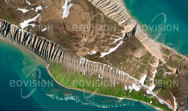 Das Satellitenbild "HOPEN - Norwegen" ist dem Bildband "WASSER - Entdeckung des Blauen Planeten" entnommen. Bildbeschreibung: Die lang gezogene Insel Hopen liegt im Südosten der norwegischen Inselgruppe Spitzbergen (Svalbard). Sie wird von aus dem Meer ragenden Tafelbergen gebildet, deren Flanken stark von den Erosionsrinnen des abfließenden Wassers geprägt sind. Im Winter machen zahlreiche Eisbären auf ihren Zügen über das Polareis hier Station.