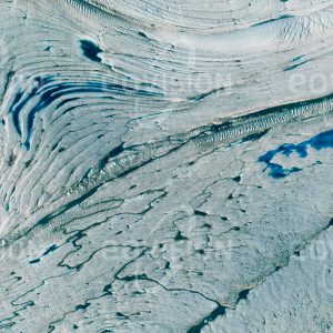Das Satellitenbild "NIOGHALVFJERDSFJORDEN - Grönland" ist dem Bildband "WASSER - Entdeckung des Blauen Planeten" entnommen. Bildbeschreibung: Auf fast 80° nördlicher Breite gelegen ist der Nioghalvfjerdsfjorden-Gletscher im Nordosten von Grönland nur etwa 1100 Kilometer vom Nordpol entfernt. Der einst vom Gletscher geformte Fjord ist heute mit Wasser gefüllt, auf dem das Eis des Gletschers schwimmt. Im Sommer bildet Schmelzwasser auf der Gletscheroberfläche kleine Seen und Bäche, die sich in das Eis graben und in blauen Schattierungen leuchten.
