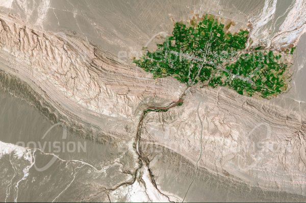 Das Satellitenbild "KESHIT - Iran" ist dem Bildband "NEW HUMAN FOOTPRINT - Unsere Welt im Umbruch" entnommen. Bildbeschreibung: In der Oasenstadt am Rand der Wüste Lut leben etwa 1000 Einwohner auf einem Schwemmfächer, der von einem Fluss nach dem Durchbruch durch die begrenzende Bergkette zur Wüste geformt wurde. Hier ist unterirdisch fließendes Wasser verfügbar, sodass Landwirtschaft betrieben werden kann. Das Dorf liegt nur 80 Kilometer nörd­lich von Bam, das 2003 von einem verhee­renden Erdbeben zerstört wurde.