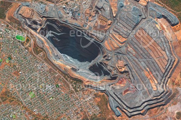 Das Satellitenbild "KALGOORLIE - Australien" ist dem Bildband "NEW HUMAN FOOTPRINT - Unsere Welt im Umbruch" entnommen. Bildbeschreibung: Die im Jahr 1893 eröffnete Goldmine bei Kalgoorlie ist eine der bekanntesten Minen Australiens und war bis 2016 auch der größte Tagebau des Kontinents, weshalb sie auch den Namen Super Pit trägt. Um eine jährliche Förderleis­tung von etwa 28 Tonnen oder 1,5 Kubikmeter Gold zu erzielen, müssen hier jedes Jahr 15 Millionen Tonnen Ge­stein aus dem Felsen gesprengt und aufbereitet werden.