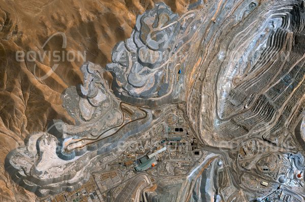 Das Satellitenbild "CHUQUICAMATA - Chile" ist dem Bildband "NEW HUMAN FOOTPRINT - Unsere Welt im Umbruch" entnommen. Bildbeschreibung: Die in 2850 Metern Höhe gelegene Chu­quicamata-Mine war lange Zeit die größte Tagbau-Kupfermine und mit mehr als 1000 Metern Tiefe eine der tiefsten der Welt. Bisher wurden mehr als 3 Milliarden Tonnen Kupfererz gefördert. Schon in prähistorischer Zeit wurden die Vorkommen ausgebeutet, wovon auch der Fund des mumifizierten „Kupfermanns“ in einem vor fast 1500 Jah­ren eingestürzten Schacht zeugt. Seit 1913 wird das Kupfererz industriell abgebaut. Als wichtiges Exportgut stellte Kupfer zeitweise bis zu 75 Prozent der chilenischen Exporte, heute ist es noch immer etwa ein Drittel.