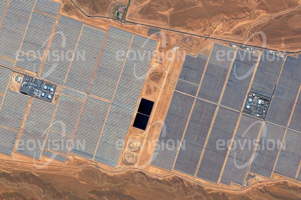 Das Satellitenbild "QUARZAZATE - SOLARKRAFTWERK - Marokko" ist dem Bildband "NEW HUMAN FOOTPRINT - Unsere Welt im Umbruch" entnommen. Bildbeschreibung: Im sonnigen Klima Marokkos soll die Ouarzazate Solar Power Station in der Drâa-Tafilalet-Region südlich des Hohen Atlas nach Fertigstellung eine Spitzenleistung von 580 Megawatt liefern. Noor I und II sind Parabolrinnenkraftwerke, welche die Sonnenenergie in Salzschmel­zen speichern. Die Reinigung der Parabolspiegel ist mit hohem Wasserverbrauch verbunden.