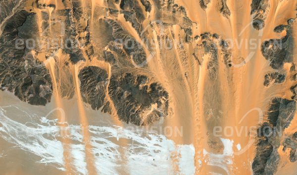 Das Satellitenbild "GUÉRÉ - Tschad" ist dem Bildband "UNTOUCHED NATURE - Naturlandschaften in Satellitenbildern" entnommen. Bildbeschreibung: Wind aus nördlicher Richtung verfrachtet Sand der Libyschen Wüste und füllt dadurch Wadis der Ausläufer des Tibesti mit Sand-dünen. Der vulkanisch aktive Tibesti im Nor­den des Tschad ist das höchste Gebirge der Sahara, in seinem trockenen, heißen Klima ist kaum Vegetation zu finden. Dennoch leben hier nomadische Tubbu, die vor allem Ziegen und Schafe halten. Dass das Klima der Sahara einst wesentlich lebensfreundlicher war, beweisen zahlreiche in diesem Gebiet gefundene Felsbilder.