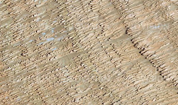 Das Satellitenbild "LENGHU - China" ist dem Bildband "UNTOUCHED NATURE - Naturlandschaften in Satellitenbildern" entnommen. Bildbeschreibung: Quer zu den großflächigen Ringstrukturen des abgetragenen Untergrunds im Qaidam-Becken hat der Wind ein dichtes Muster von felsigen Erhebungen, so genannte Yardangs oder Windhöcker, herausgearbeitet. Die Schatten und vom Wind verfrachteter, etwas dunklerer Sand lassen diese Strukturen besonders deutlich hervortreten. Obwohl die Landschaft äußerst unwegsam ist, wird ihr seit einigen Jahren wegen ihrer Bodenschätze vermehrt Aufmerksamkeit zuteil.