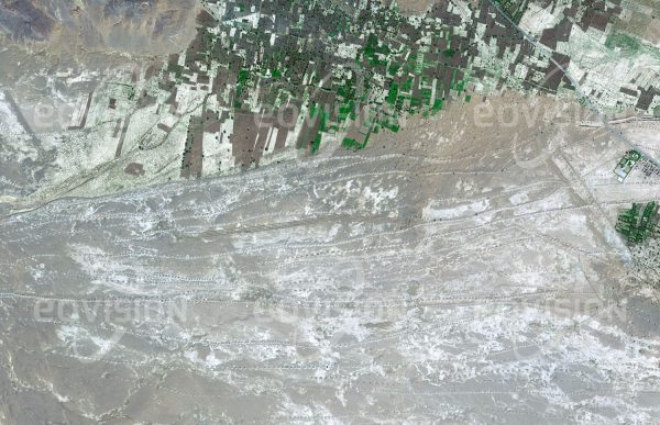 Das Satellitenbild "EL JORF - Marokko" ist dem Bildband "WÜSTEN - Lebensraum der Extreme" entnommen. Bildbeschreibung: Qanate sind eine alte Variante unterirdischer Wasserkanäle. In der Umgebung der Oasensiedlung El Jorf in den Ausläufern des Atlas-Gebirges ist die Oberfläche von einem dichten Netz von Qanaten überzogen, durch welches Wasser zu den Anbauflächen der Oase geleitet wird. Zwischen den Reihen der Aushubkegel sind auch Windschutzgürtel zu erkennen, welche die Oase vor vom Wind verfrachteten Sand schützen soll.