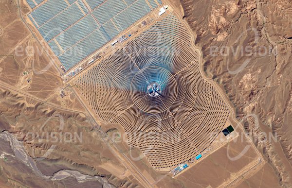 Das Satellitenbild "OUARZAZATE - Marokko" ist dem Bildband "WÜSTEN - Lebensraum der Extreme" entnommen. Bildbeschreibung: Das Klima weiter Teile Nordafrikas eignet sich ausgezeichnet für eine Nutzung der Sonnenenergie. So soll die Ouarzazate Solar Power Station in der Drâa-Tafilalet-Region südlich des Hohen Atlas nach Fertigstellung eine Spitzenleistung von 580 Megawatt liefern. Der Bau erfolgt in mehreren Phasen. Noor I und II sind Parabolrinnenkraftwerke, welche die in der Tageshitze aufgefangene Sonnenenergie in Salzschmelzen speichern. Dieser Kraftwerkstyp ist mit einem hohen Wasserverbrauch für die Reinigung der Parabolspiegel verbunden.